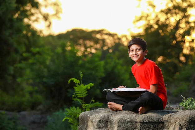 Niño de la escuela india con cuaderno y estudiar en casa