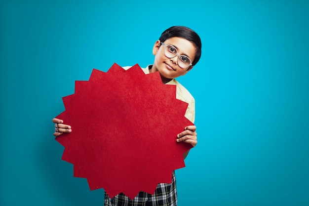 Niño de la escuela india mostrando tablero con espacio de copia