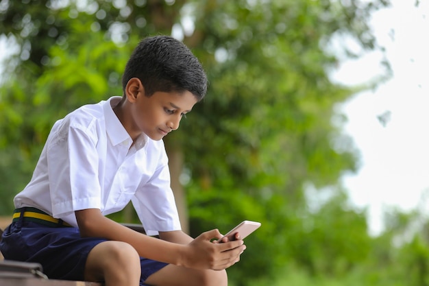 Niño de la escuela india con la pantalla del teléfono inteligente. concepto de educación en línea.