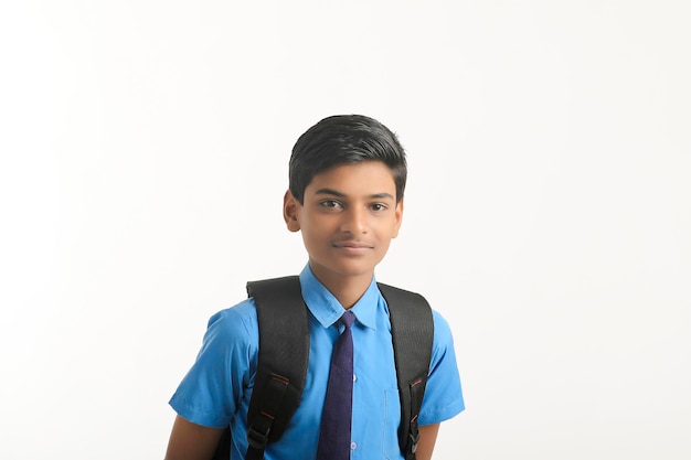 Niño de la escuela india de pie sobre fondo blanco.