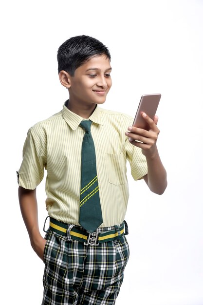 Niño de la escuela india con smartphone. concepto de educación en línea.