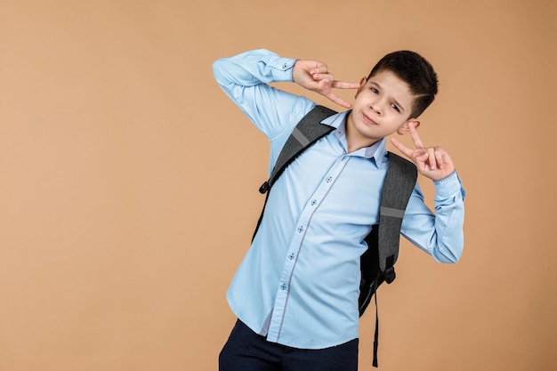 Un niño de escuela con una mochila gris.