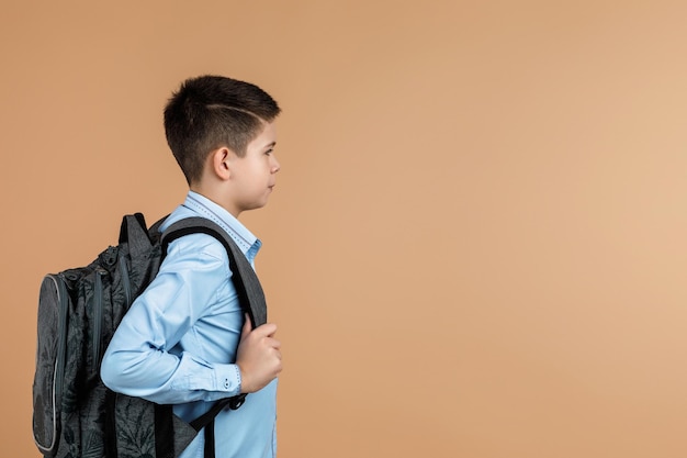 Un niño de escuela con una mochila gris.