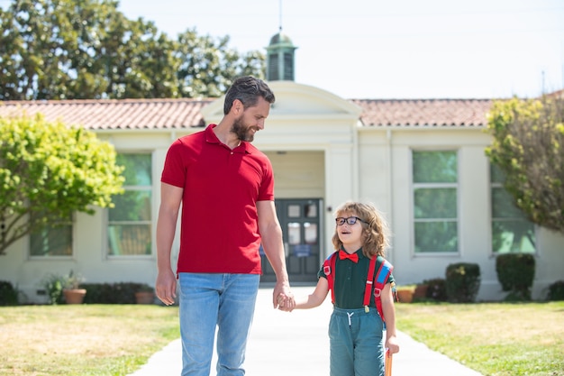 Niño de la escuela que va a la escuela con el padre