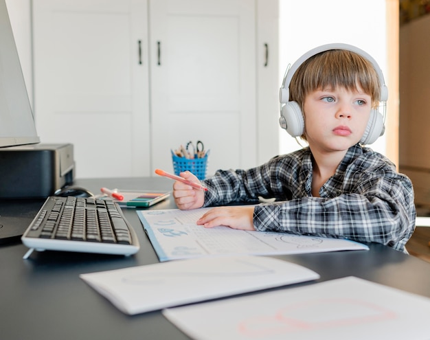 Foto niño de la escuela tomando cursos en línea