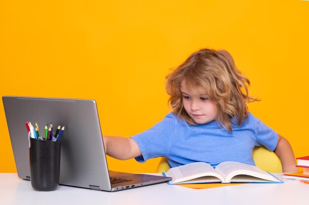 Niño de la escuela usando una computadora portátil Escuela y niños Lindo niño rubio con un libro aprendiendo Día del conocimiento