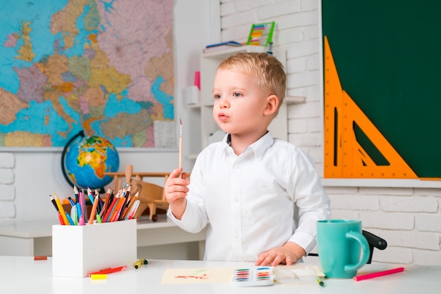 El niño está aprendiendo en clase en el fondo del día del maestro de pizarra niño talentoso lindo pequeño prescho