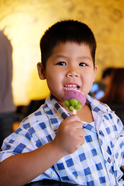 El niño está comiendo helado de frutas.