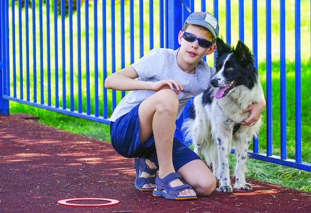 El niño está en cuclillas junto al perro.