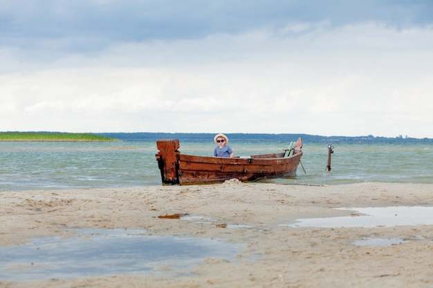 Niño está descansando en un bote en el lago