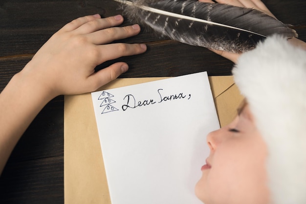 Niño está durmiendo en la mesa Carta para Santa Fondo de madera