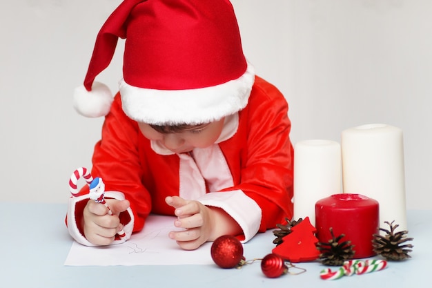 Niño está escribiendo una carta a Santa Claus