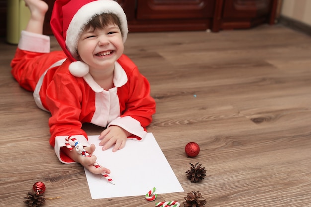 Niño está escribiendo una carta a Santa Claus