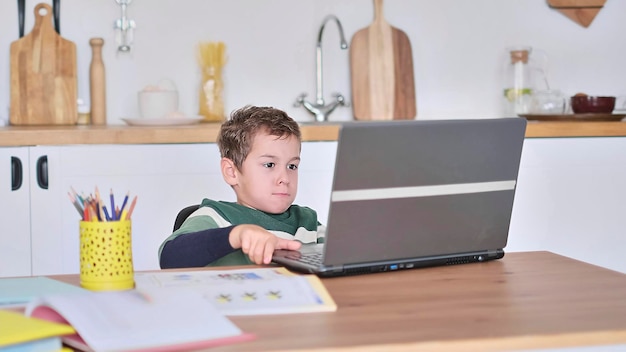 El niño está estudiando en una escuela en línea que muestra la respuesta a la pregunta a través de la comunicación por video.