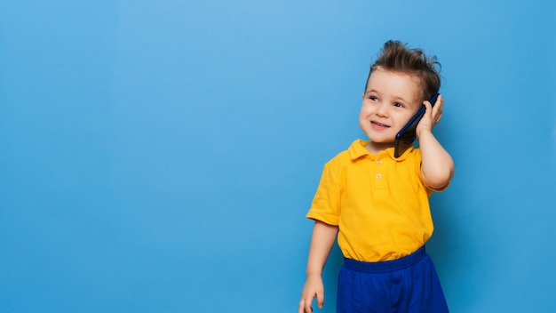 Un niño está hablando por un teléfono móvil.