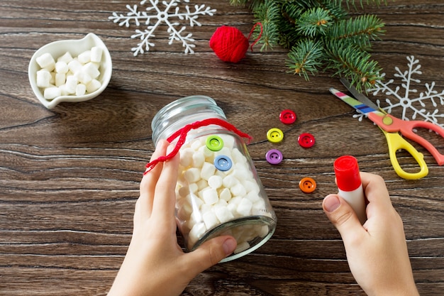 Un niño está haciendo un regalo de Navidad con un muñeco de nieve de dulces.