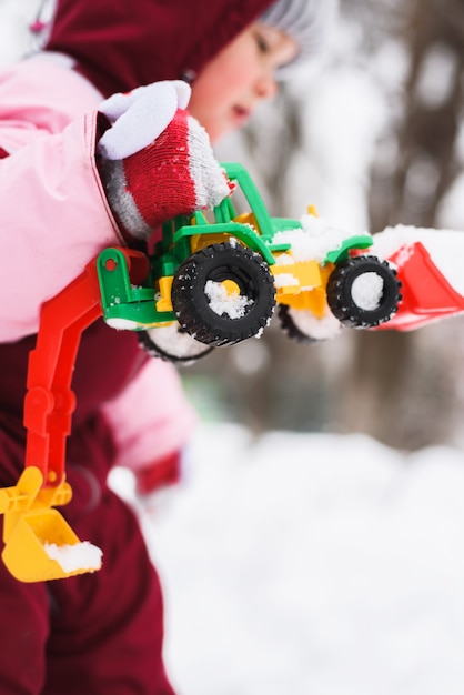 Niño está jugando con juguetes en el invierno en el parque