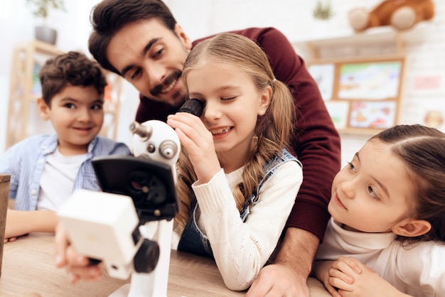 Un niño está mirando a través de un microscopio.