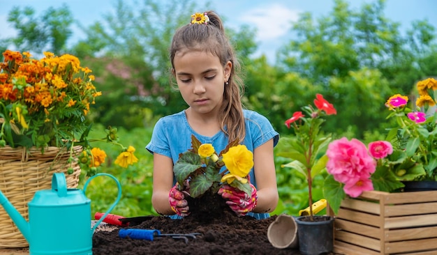 El niño está plantando flores en el jardín Enfoque selectivo