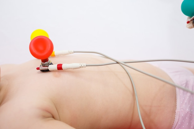 El niño está siendo preparado para un electrocardiograma del corazón, diagnóstico de enfermedad cardíaca en niños.