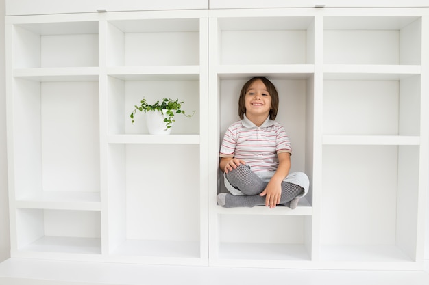 Niño en el estante dentro de la sala de estar