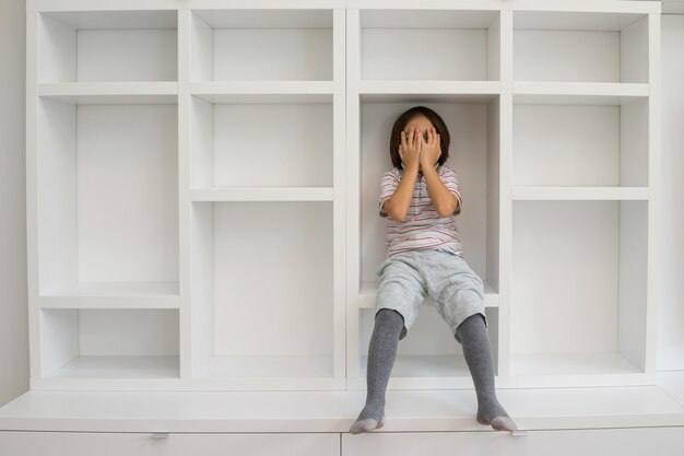 Niño en estantes en casa