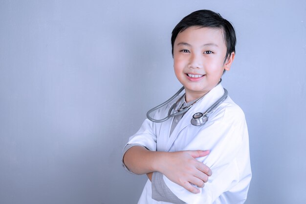 Niño y estetoscopio en uniforme médico con espacio de copia.