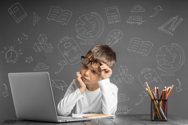 El niño estudia a distancia en la escuela. De vuelta a la escuela