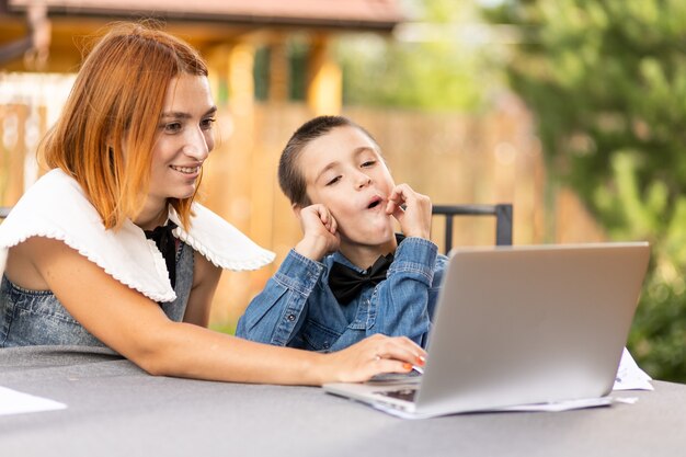 Niño estudiando desde casa en un aula online en la nueva normalidad. El colegial escucha una conferencia y resuelve problemas