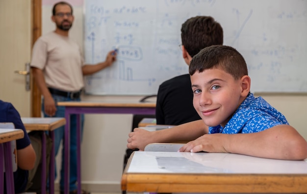 Niño estudiando en la escuela con sus colegas