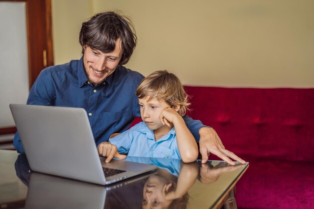 Niño estudiando en línea en casa usando una computadora portátil El padre lo ayuda a aprender Estudiar durante la cuarentena Virus pandémico global covid19