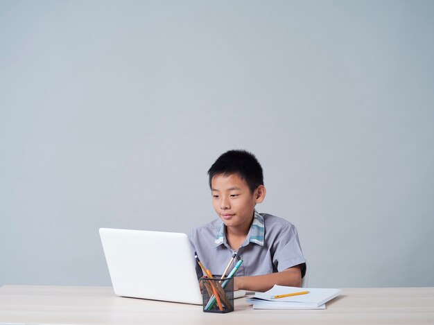 Niño estudiando en línea con un portátil. Aprendizaje a distancia durante la pandemia de COVID-19