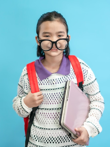 Niño estudiante, niños asiáticos cerca de gente linda y alegre, usando anteojos y sosteniendo una computadora portátil