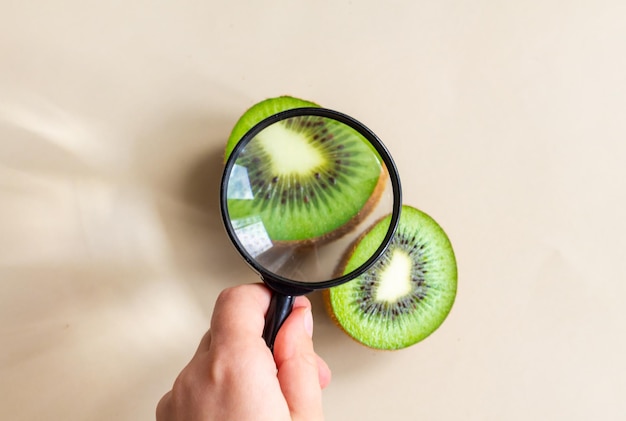 Un niño examina las mitades de un kiwi con una lupa
