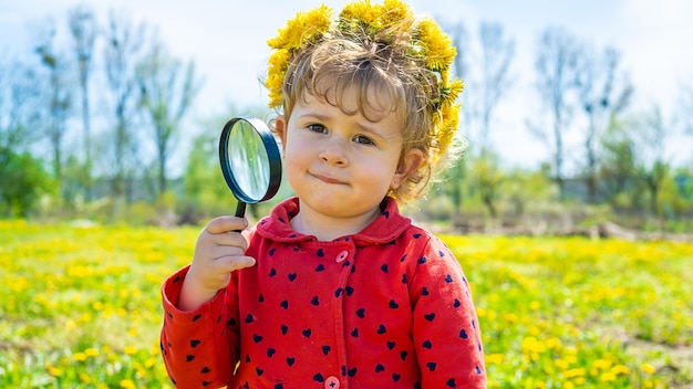 Un niño examina las plantas con una lupa Enfoque selectivo