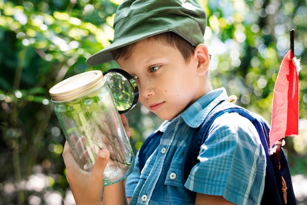 Niño examinando una planta con una lupa