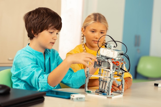 Niño explicando a sus compañeros de clase los principios de trabajo de su proyecto