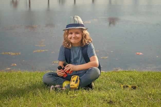 Niño explorador con sombrero de explorador y mochila al aire libre Explorador y aventura con binocular