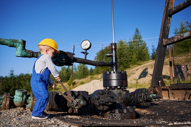 Niño explorando herramientas de trabajo cerca de un oleoducto