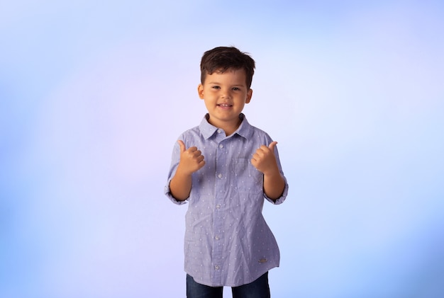 Niño con expresiones faciales en una foto de estudio sobre fondo de color.