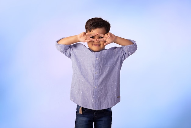 Niño con expresiones faciales en una foto de estudio sobre fondo de color.