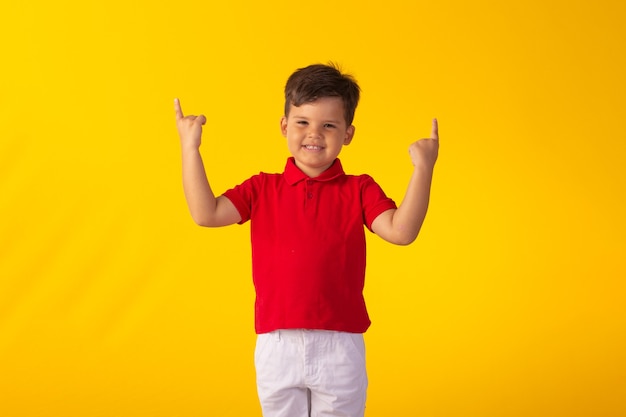 Niño con expresiones faciales en una foto de estudio sobre fondo de color.