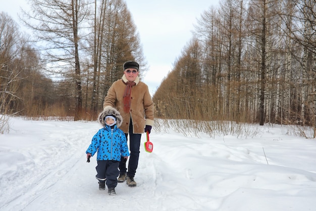 Niño con familia divertirse en un parque de invierno