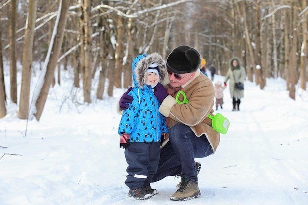 Niño con familia divertirse en un parque de invierno