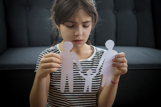 Niño con una familia de papel en sus manos.