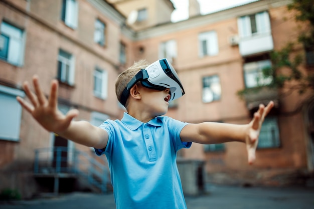 Niño fascinado con gafas de realidad virtual VR. al aire libre