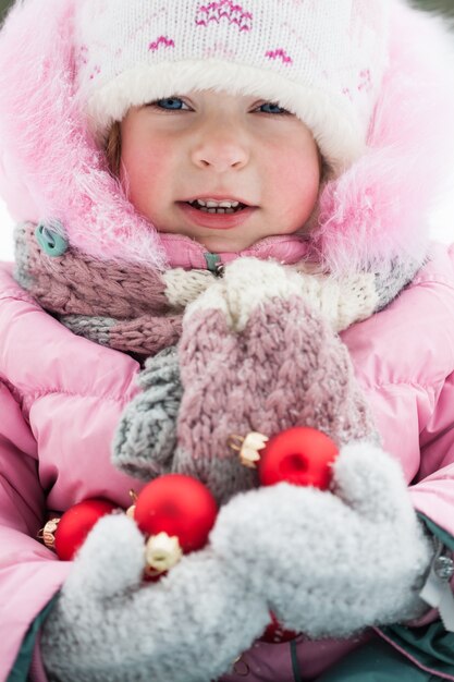 Niño feliz con adornos navideños en Winter Park. Tiro al aire libre