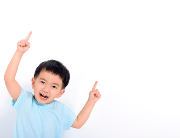 Niño feliz apuntando al espacio de la copia