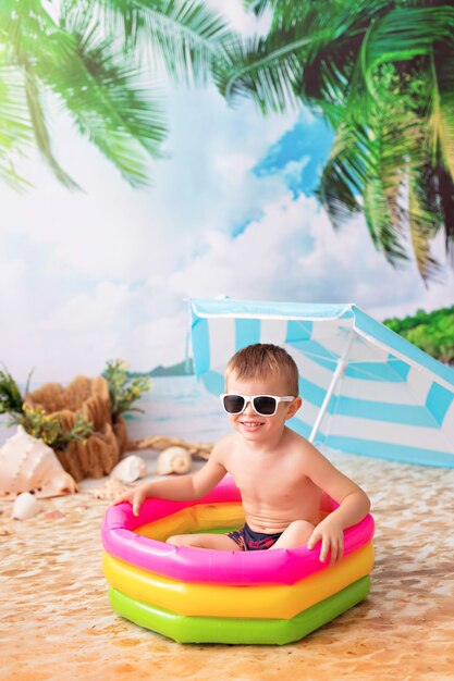 Niño feliz se baña en una piscina inflable brillante