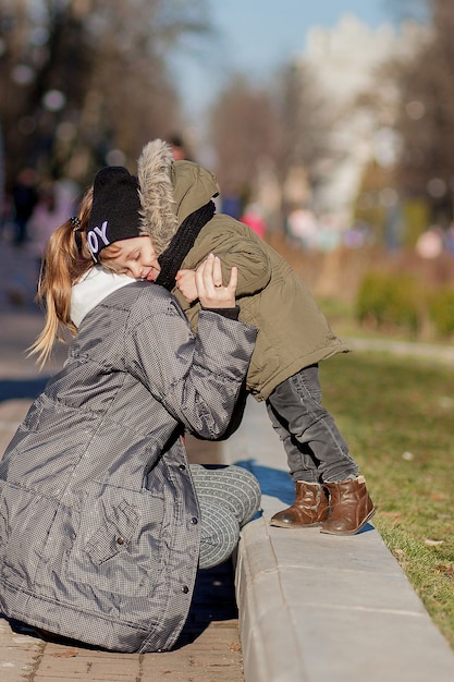 Niño feliz besando a la madre al aire libre. Día de la Madre